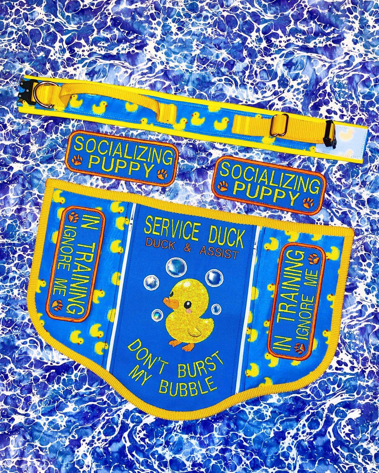 Blue and yellow convertible service vest embroidered Service Duck, duck and assist, don't burst my bubble, with rubber ducks and a matching duck collar.